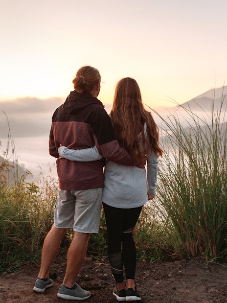 Couple viewing Mount Batur during sunrise trek in Bali.
