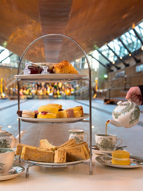 Afternoon tea setup with sandwiches and pastries at Cutty Sark, Greenwich.