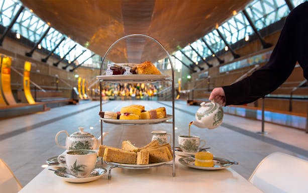 Afternoon tea setup with sandwiches and pastries at Cutty Sark, Greenwich.