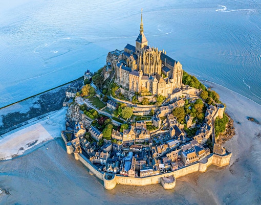 Mont Saint-Michel aerial view with abbey and surrounding bay in Normandy, France.