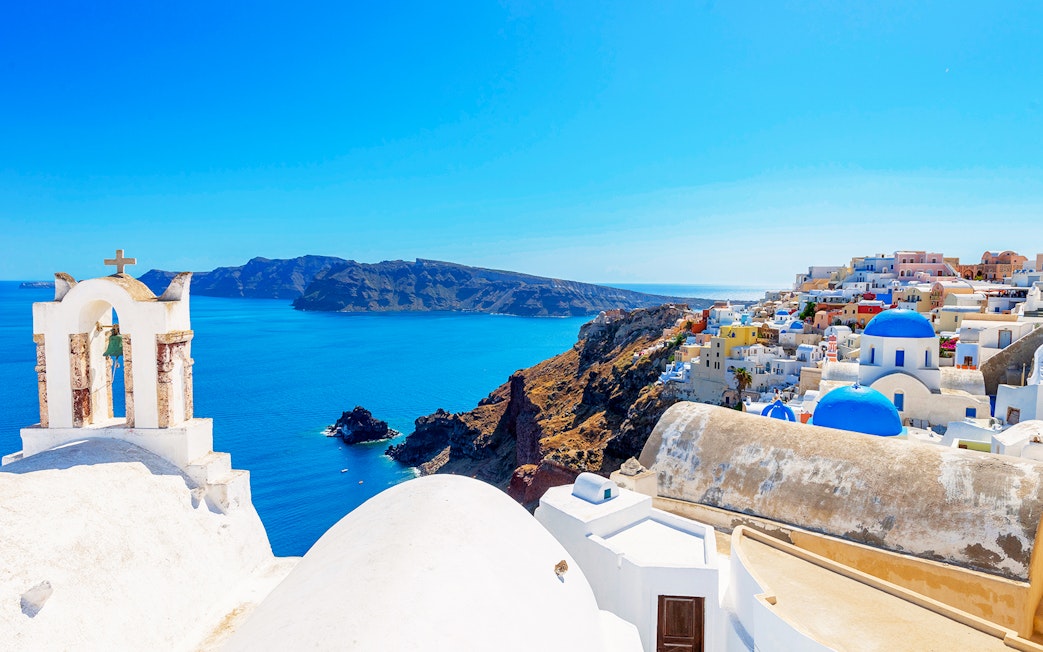 Santorini's Oia village with blue domes and Aegean Sea view.