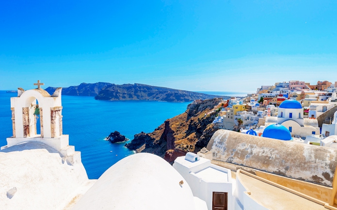 Santorini's Oia village with blue domes and Aegean Sea view.