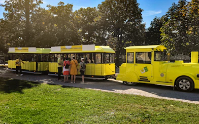 Panorama train at Schönbrunn Palace with visitors boarding.