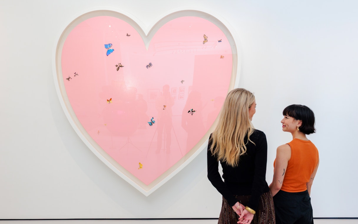 Guests viewing heart-shaped art with butterflies at Moco Museum London.