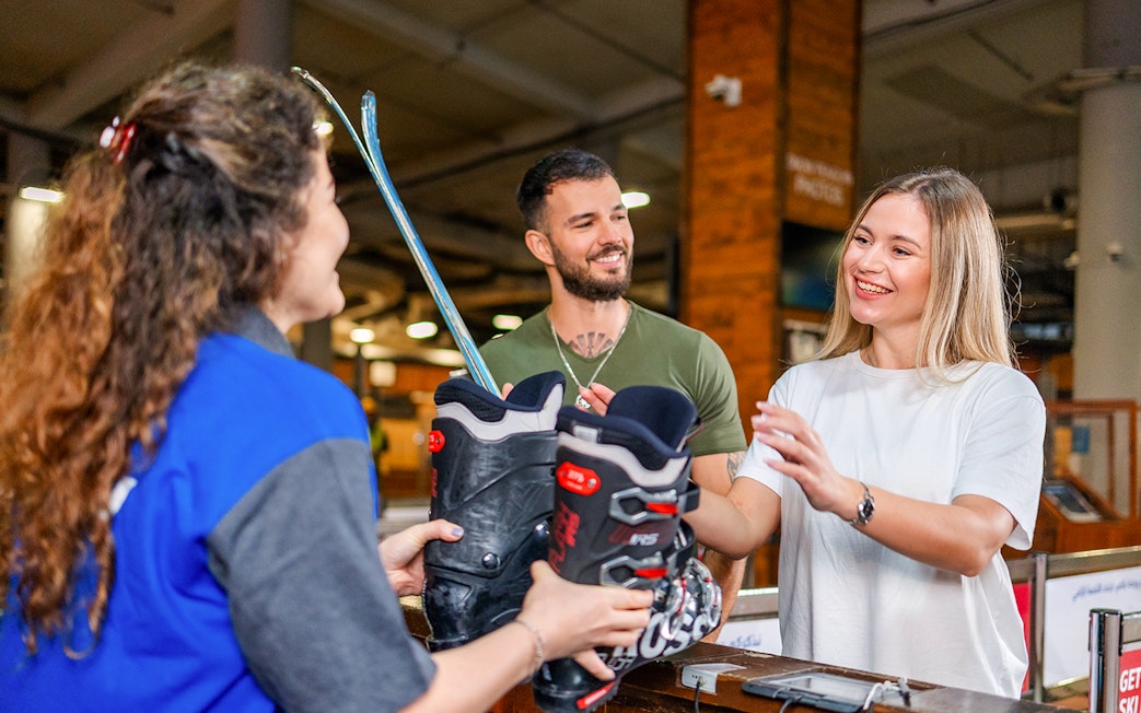 Couple receiving ski equipment at Ski Dubai.