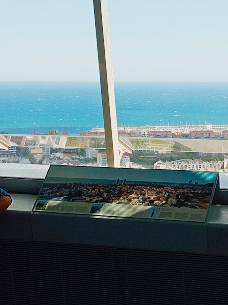 Tourist enjoying city and sea view from inside Glories Skyline Tower, Barcelona.
