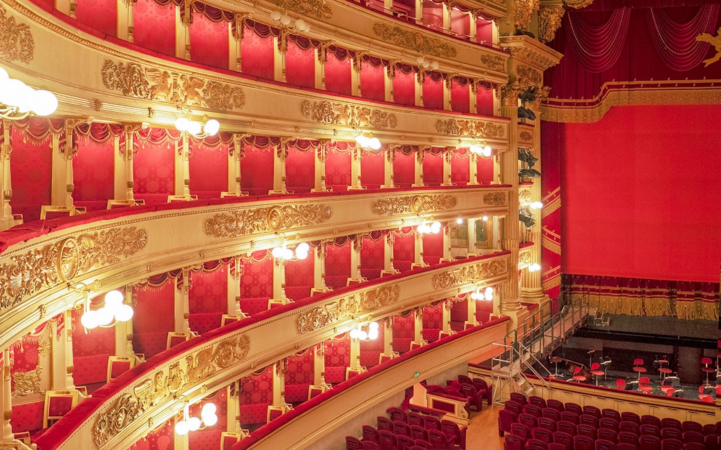 Balconies and stage of La Scala Theatre, Milan, with ornate gold detailing and red velvet seating.