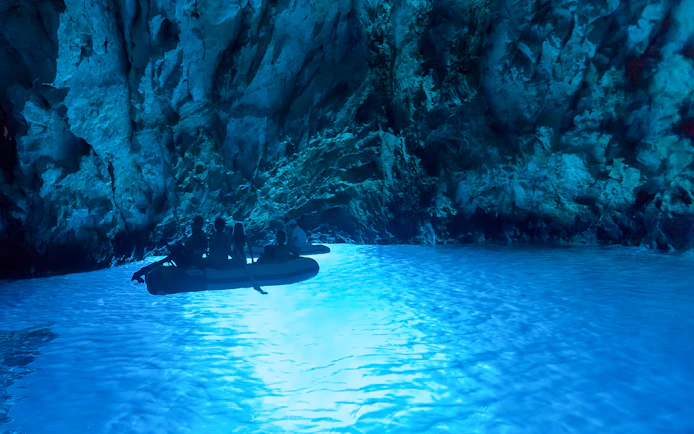 Boat tour inside a glowing blue cave on Dubrovnik Island-Hopping Cruise in the Elaphites.