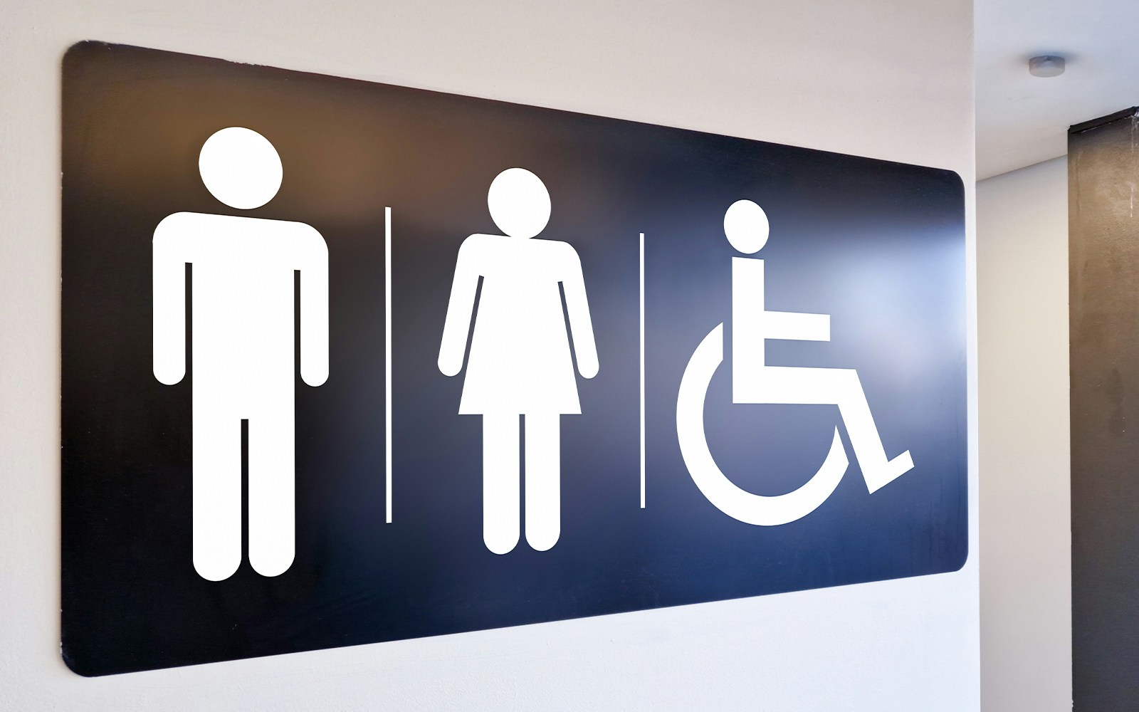 Restroom sign with symbols for men, women, and wheelchair accessibility.