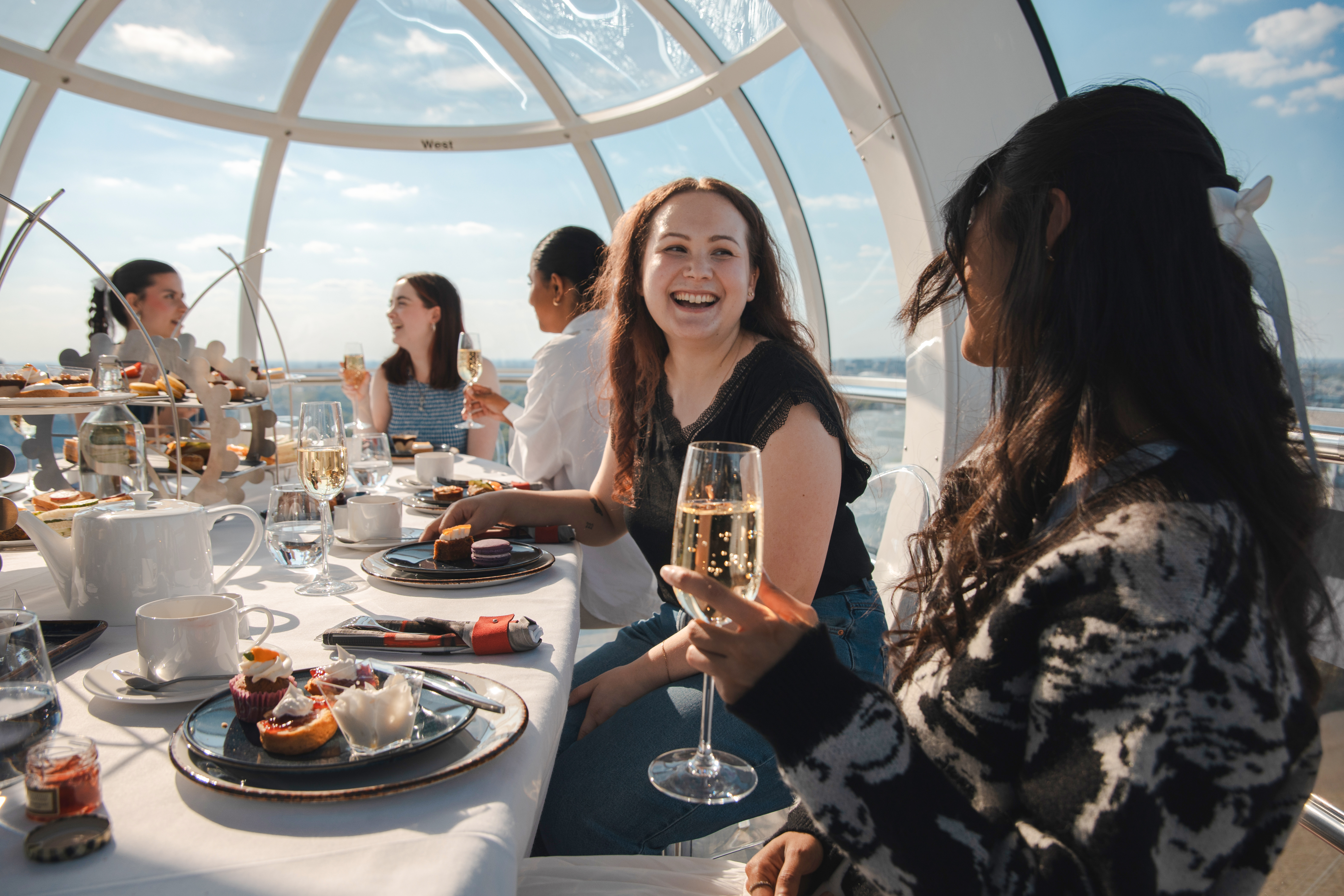 Guests enjoying afternoon tea inside a London Eye capsule.