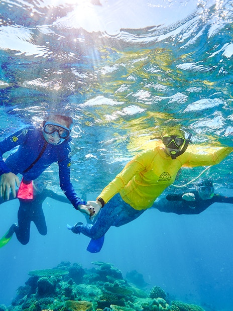 Snorkelers exploring coral reefs near Fitzroy and Green Islands.