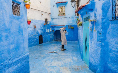 Photographer capturing blue alley in Chefchaouen, Morocco.