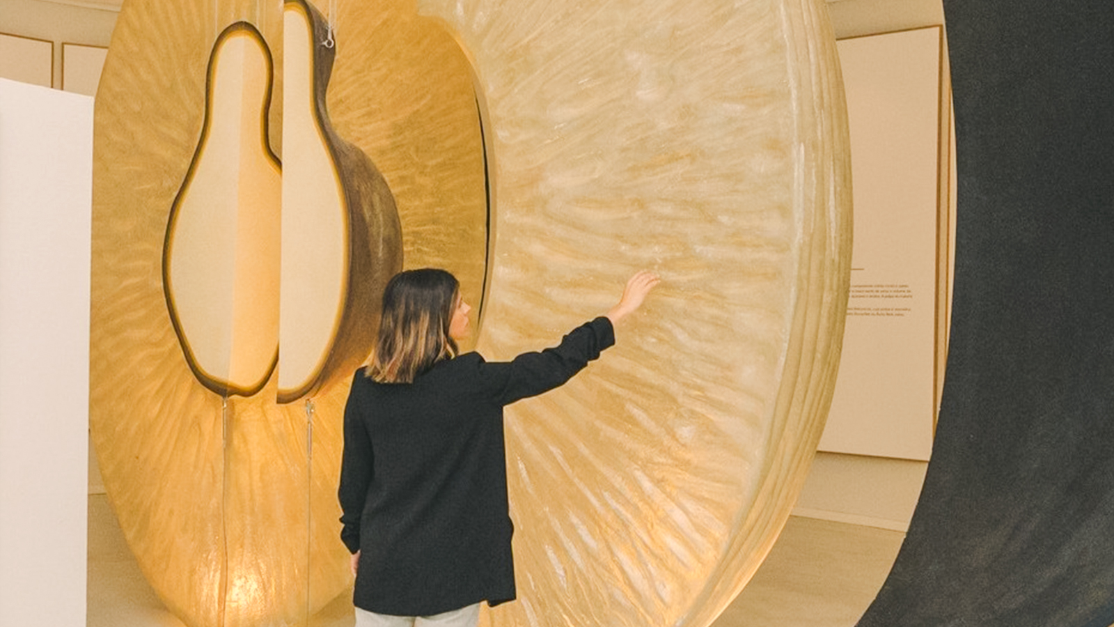 Person exploring large wine-themed sculpture at The Wine Experience exhibit.