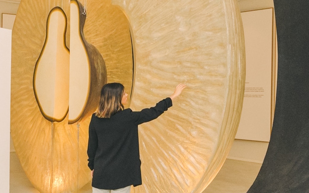 Person exploring large wine-themed sculpture at The Wine Experience exhibit.