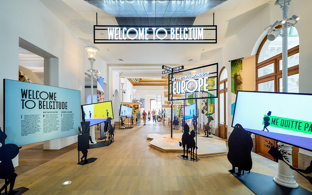 Brussels museum exhibit with "Welcome to Belgium" sign, part of hop-on hop-off bus tour.