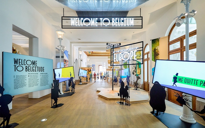 Brussels museum exhibit with "Welcome to Belgium" sign, part of hop-on hop-off bus tour.