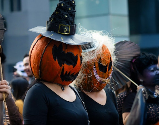 Participants in pumpkin head costumes at Halloween parade, New Orleans.