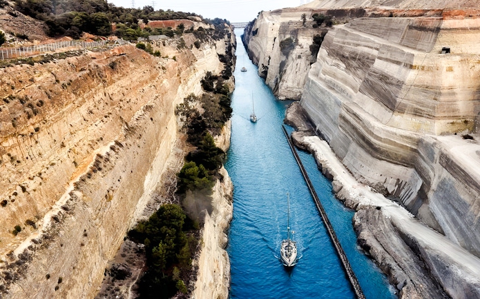 Sailboats navigating the narrow Corinth Canal in Greece.