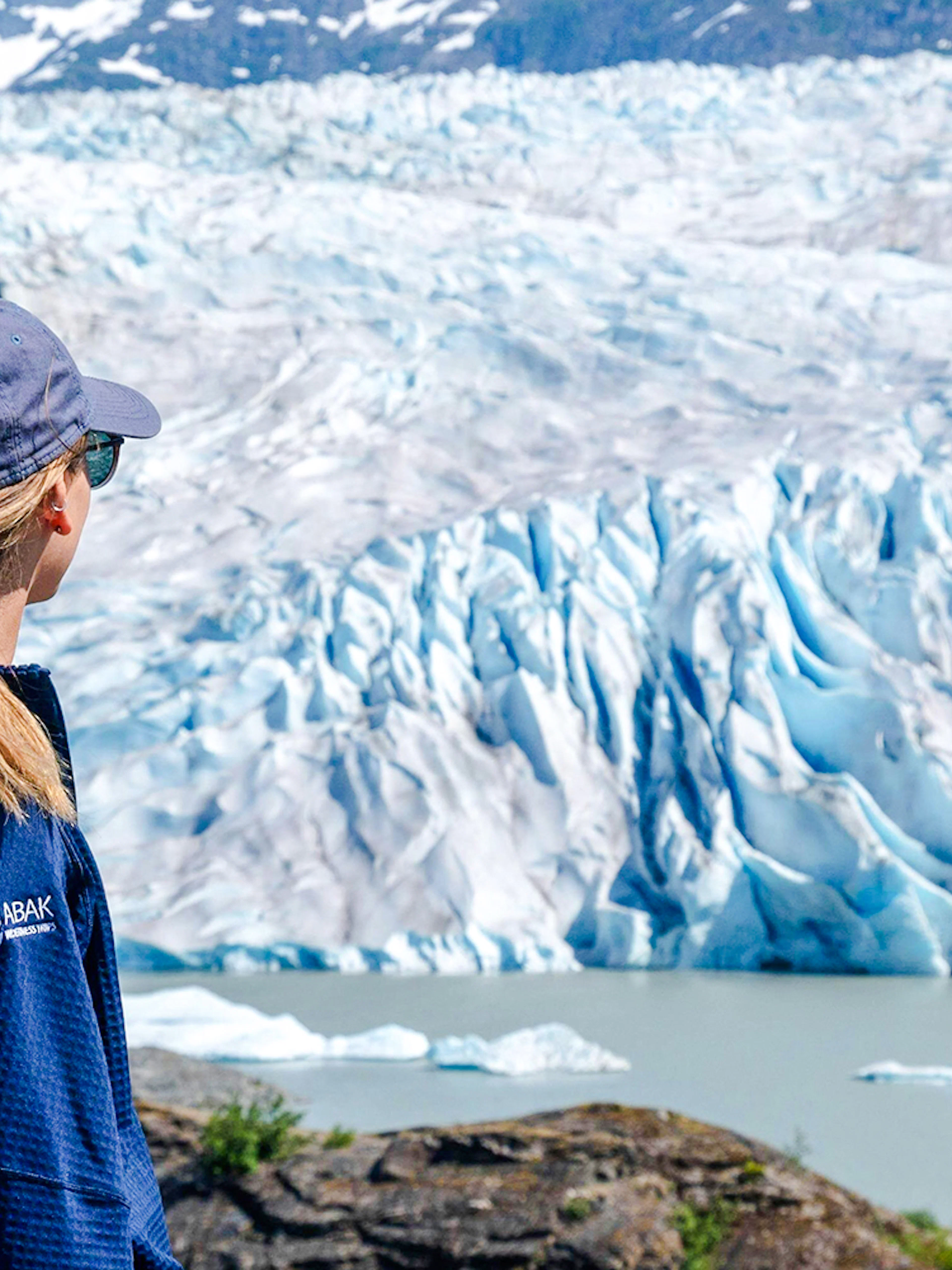 Person observing Mendenhall Glacier in Juneau, Alaska during a guided hike.