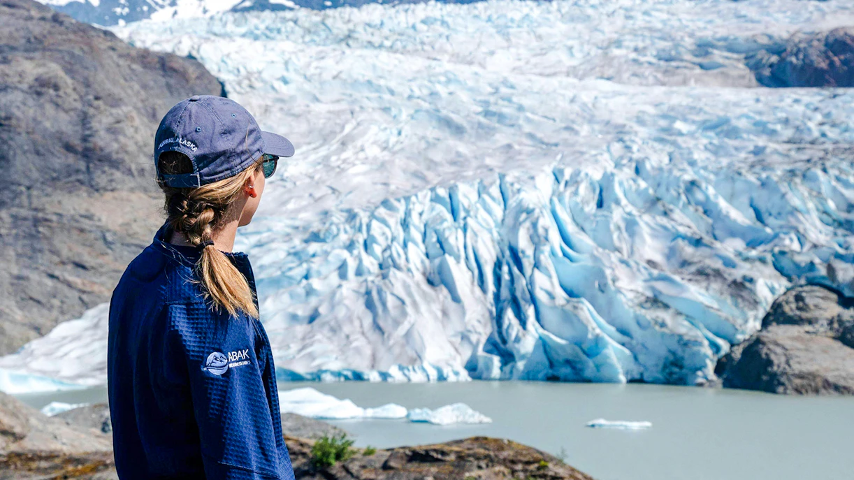 Person observing Mendenhall Glacier in Juneau, Alaska during a guided hike.