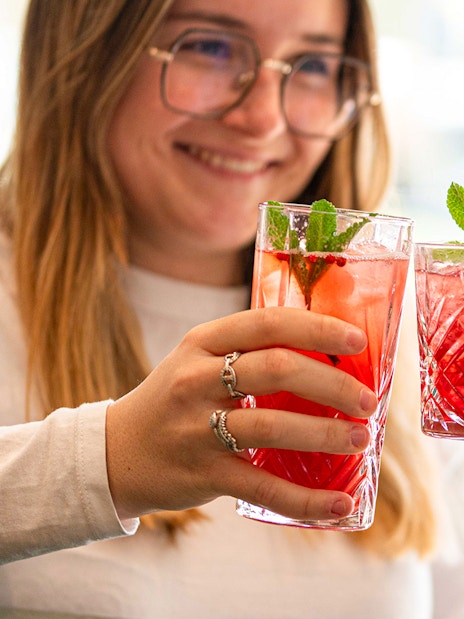 Guests toasting with red cocktails at Flora Danica, Champs Elysées, Paris.