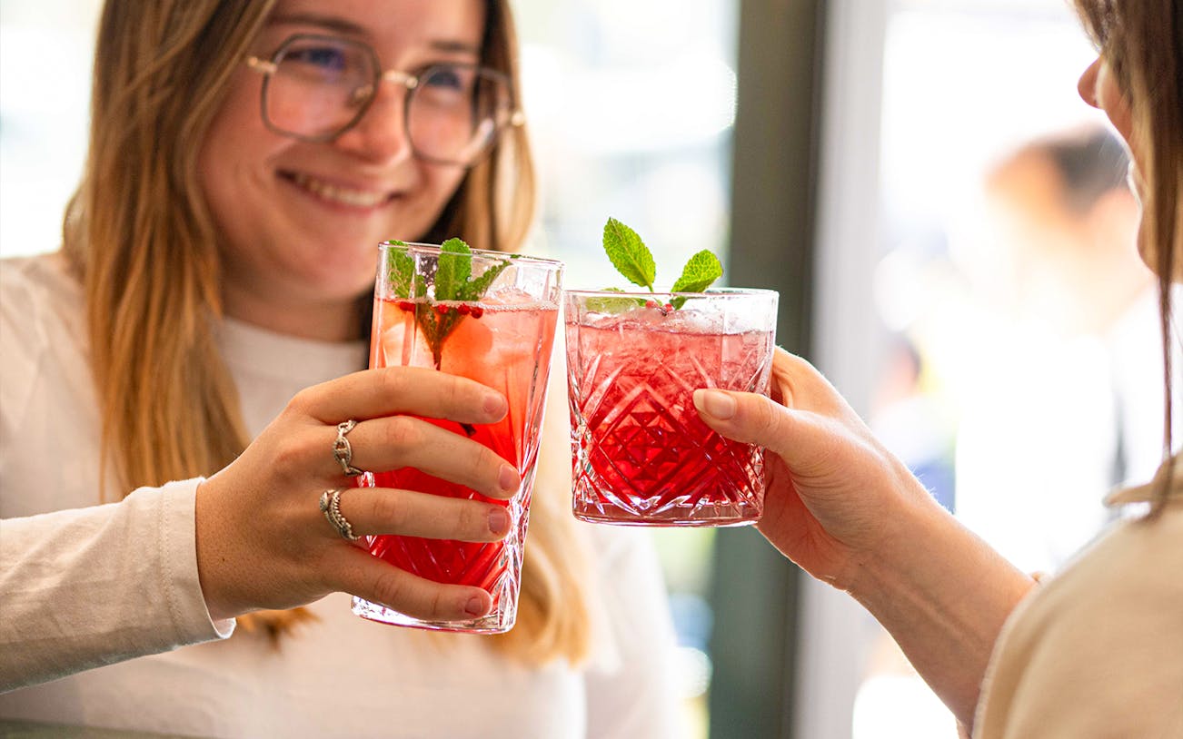 Guests toasting with red cocktails at Flora Danica, Champs Elysées, Paris.