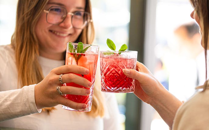 Guests toasting with red cocktails at Flora Danica, Champs Elysées, Paris.