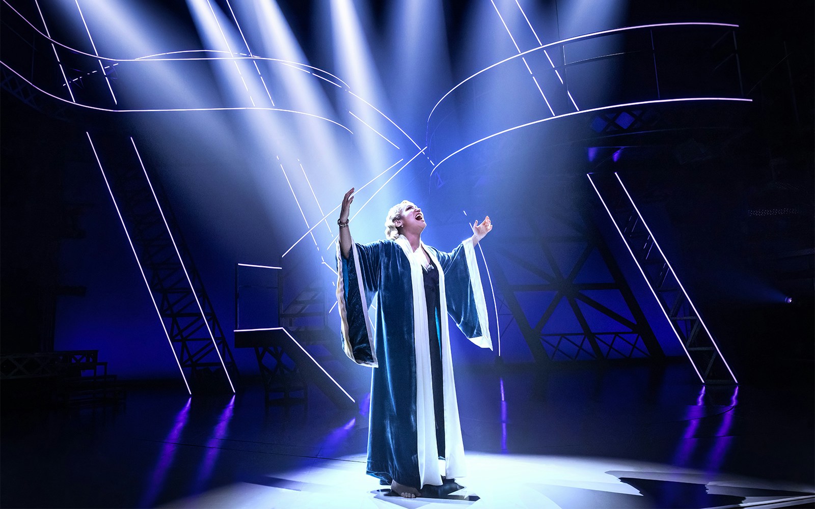 Performer on stage under dramatic lighting in a scene from the Lempicka show.