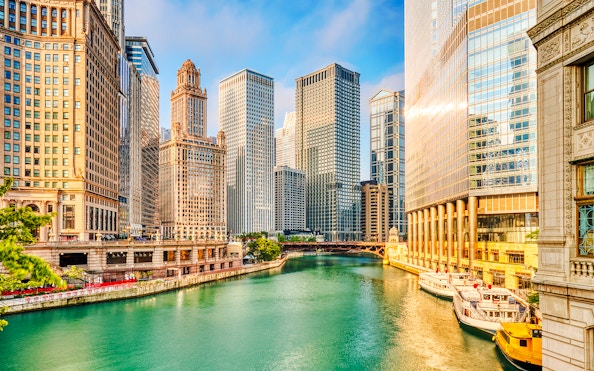 Chicago River with skyscrapers at sunrise in downtown Chicago.