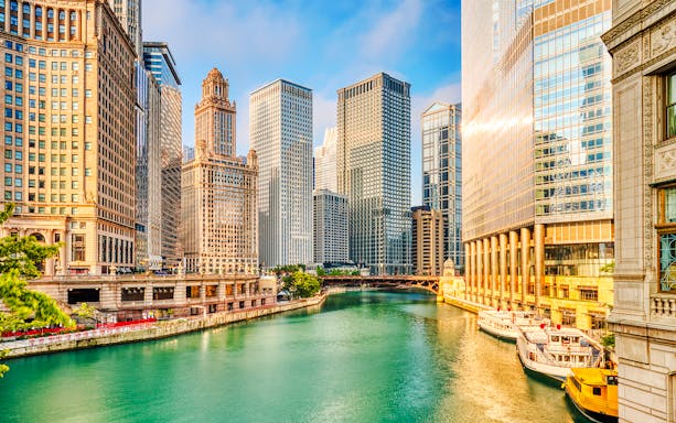 Chicago River with skyscrapers at sunrise in downtown Chicago.