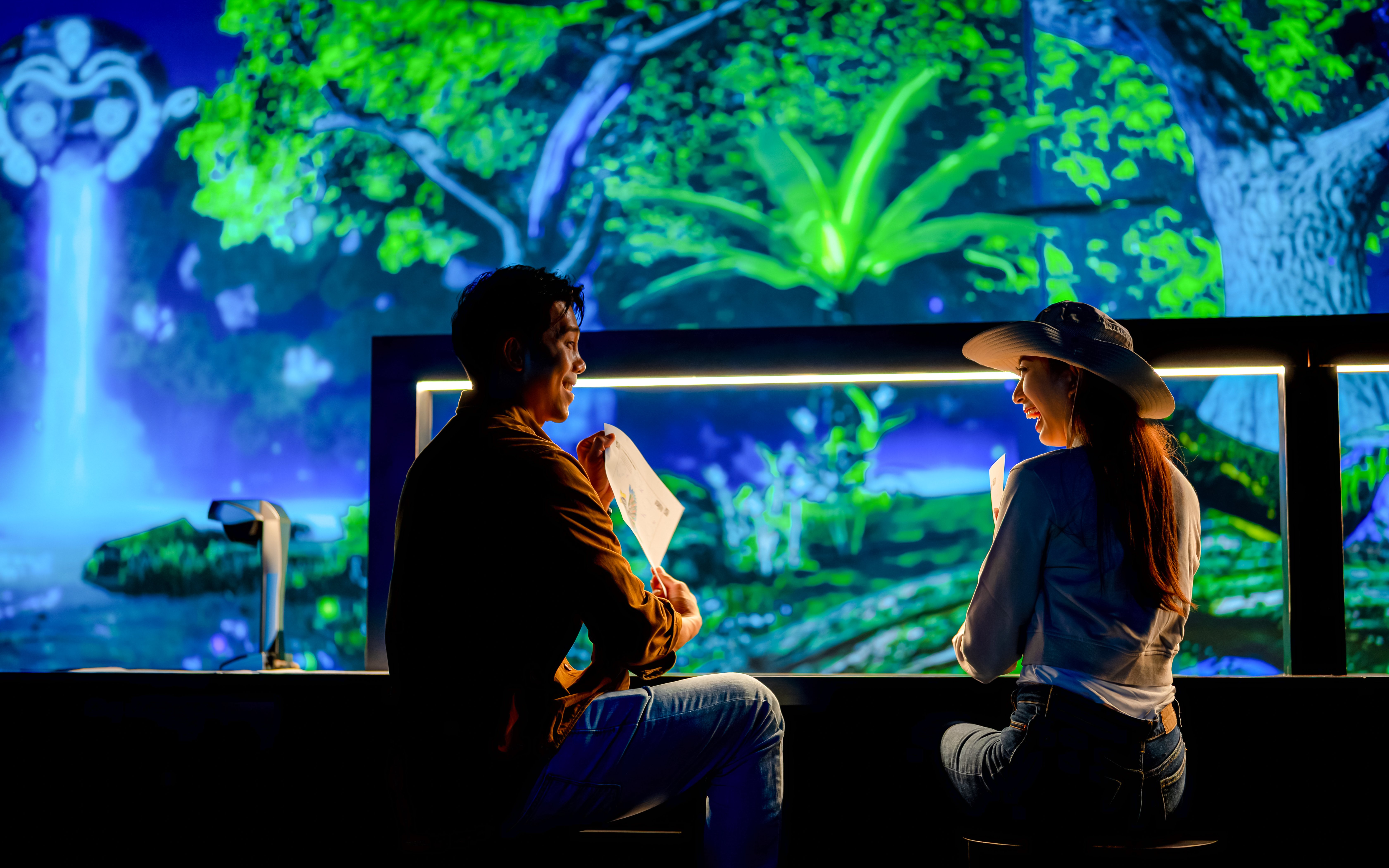 Tourists enjoying colorful displays at Enchanted Forest exhibit.