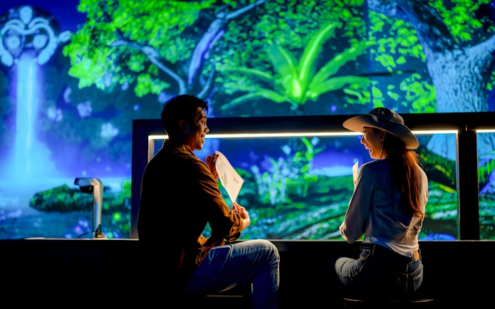 Tourists enjoying colorful displays at Enchanted Forest exhibit.