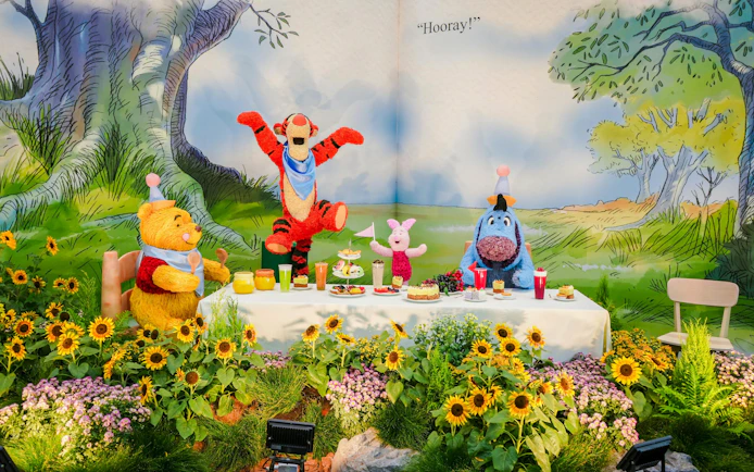 Characters enjoying a picnic in Disney Garden of Wonder with sunflowers and treats.