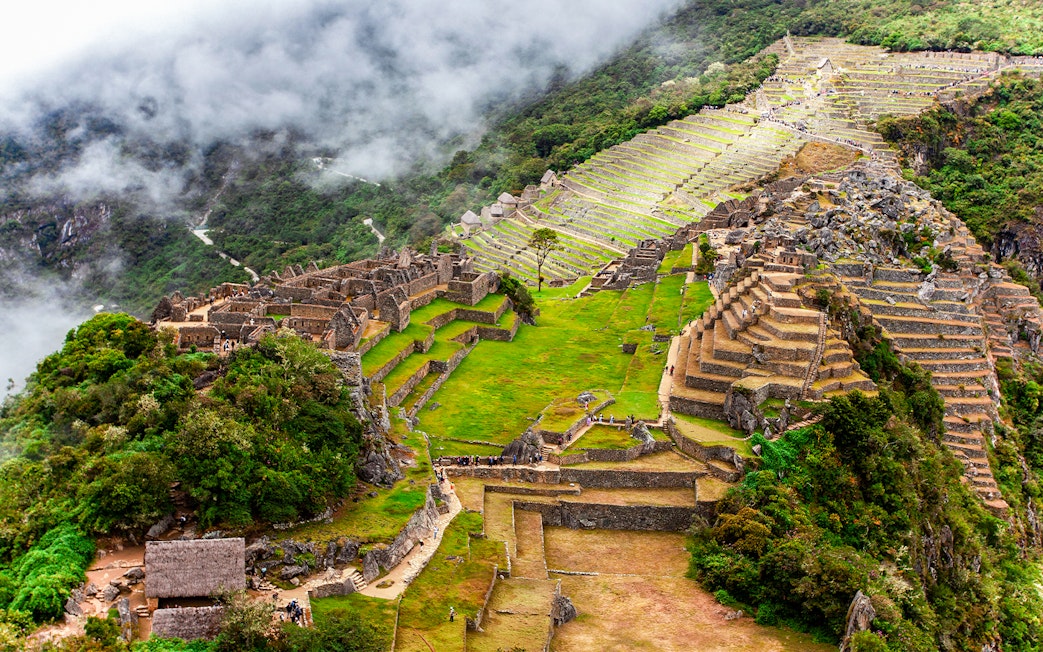 View of Machu Picchu terraces and ruins from Huchuy Picchu summit.