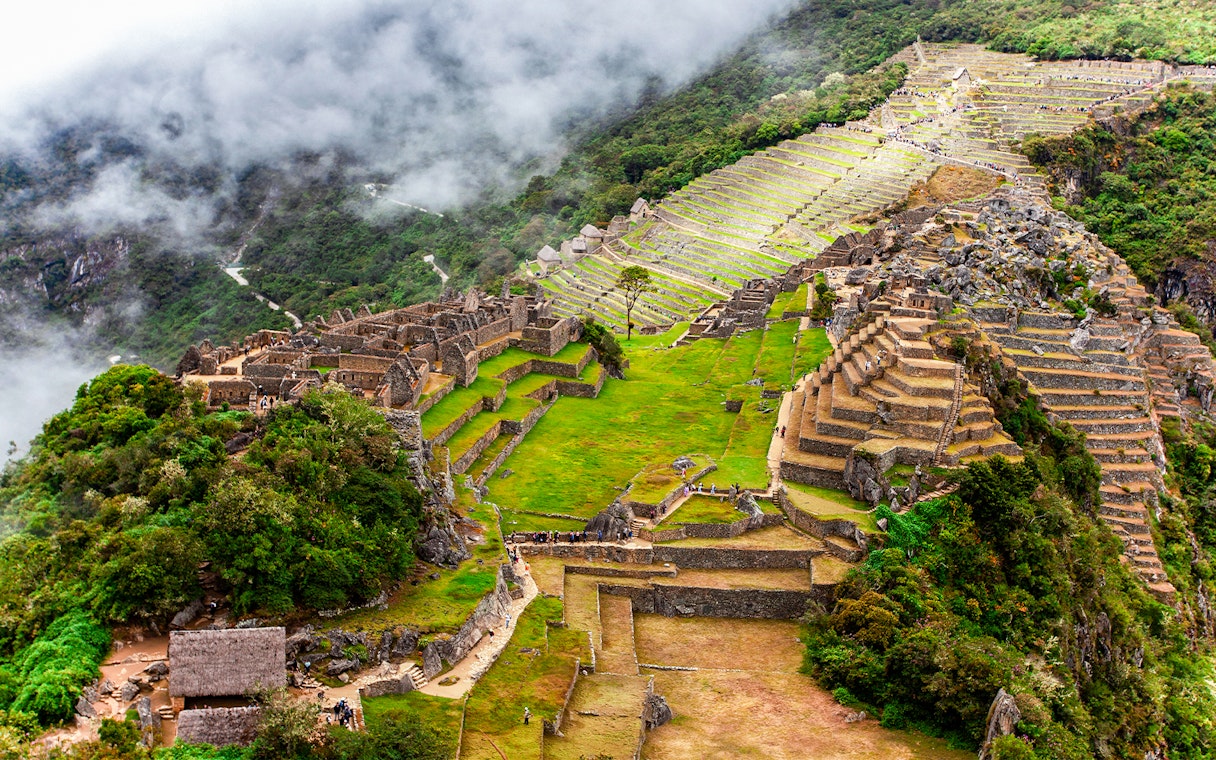 View of Machu Picchu terraces and ruins from Huchuy Picchu summit.
