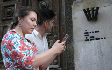 Participants using a phone for the Bergen Murder Mystery city exploration game.