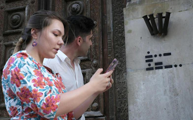 Participants using a phone for the Bergen Murder Mystery city exploration game.