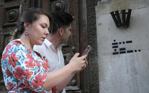 Participants using a phone for the Bergen Murder Mystery city exploration game.