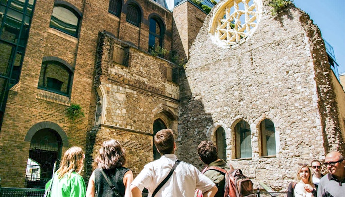 Visitors exploring historic ruins on the Eating London: Borough Market & Bankside Food Tour.
