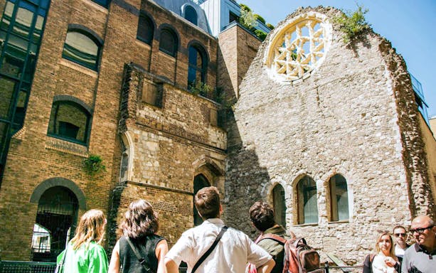 Visitors exploring historic ruins on the Eating London: Borough Market & Bankside Food Tour.