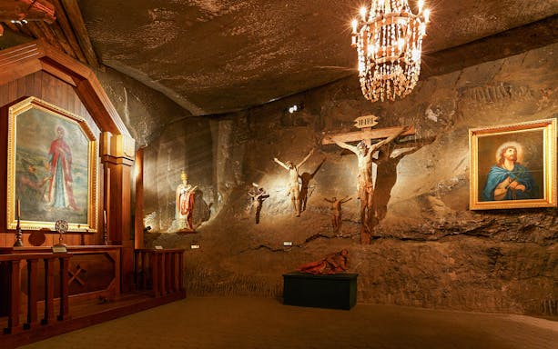 Wieliczka Salt Mine chapel with religious sculptures and paintings.