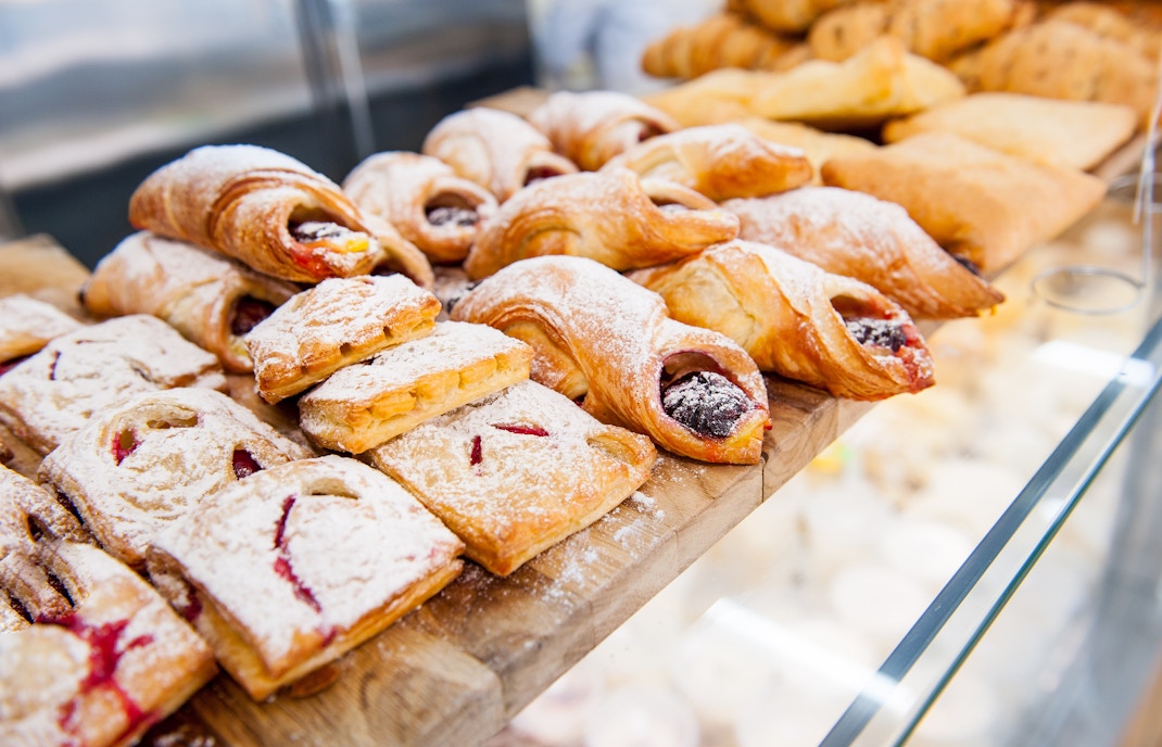 Assorted pastries with fruit filling and powdered sugar on display.