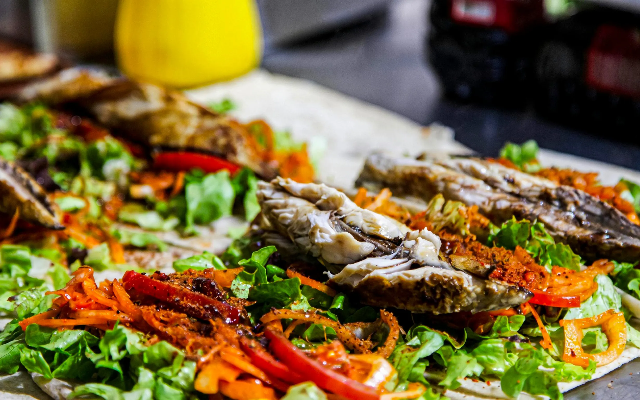 Grilled fish with lettuce and vegetables on flatbread during Istanbul food tour.