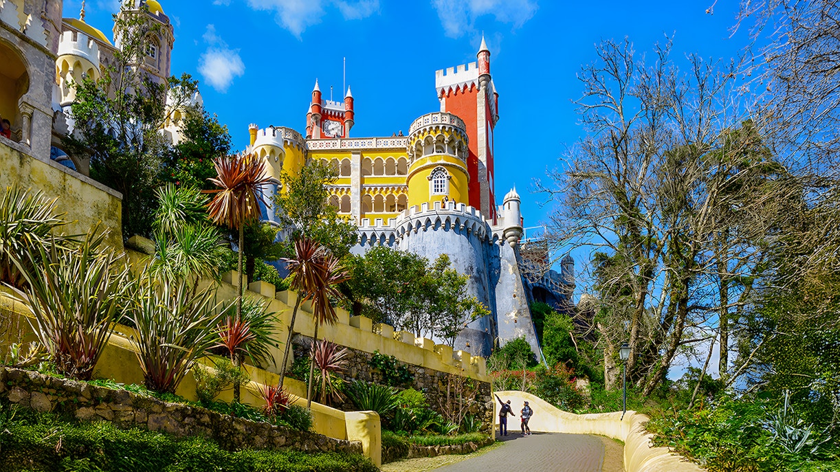 Pena Palace slope path in Sintra, Portugal, leading through lush greenery.