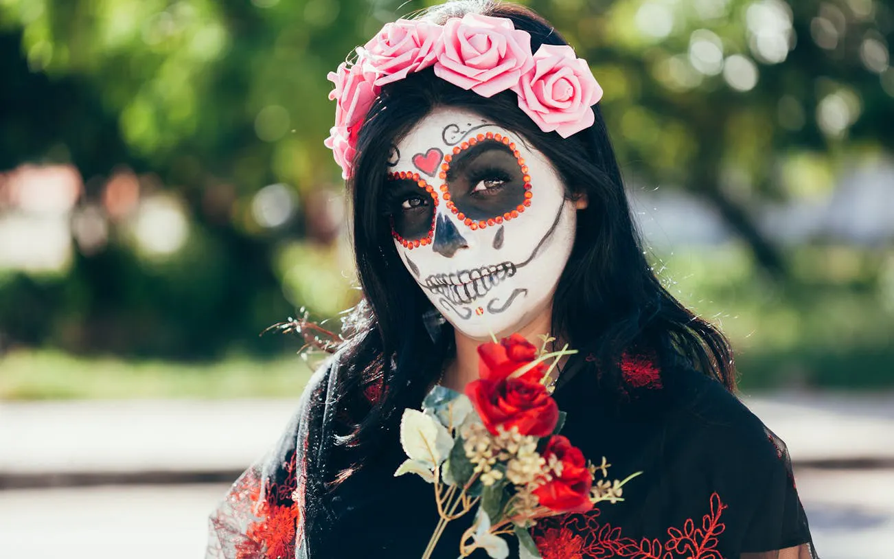 Woman with Day of the Dead face paint and flower crown at Mixquic celebration.