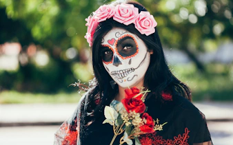 Woman with Day of the Dead face paint and flower crown at Mixquic celebration.
