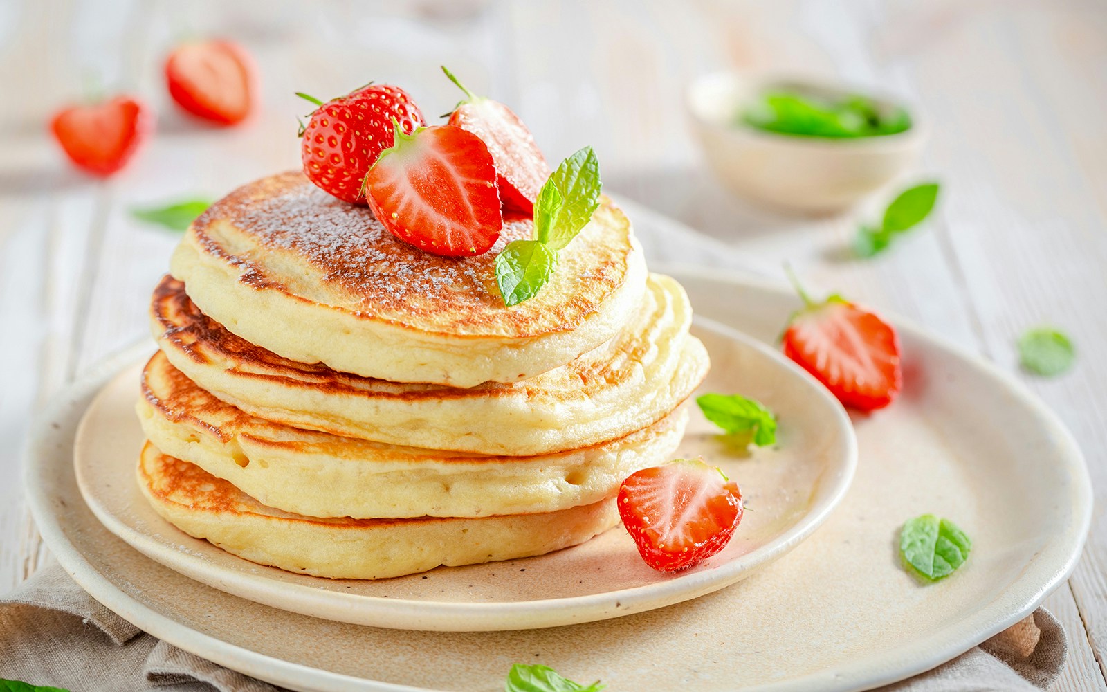 Stack of pancakes with syrup and butter on top.