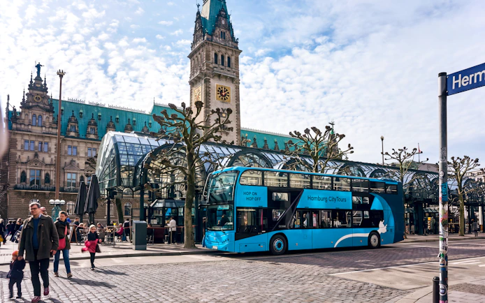 Hamburg Hop-On Hop-Off bus at Rathausmarkt stop near Hamburg City Hall.