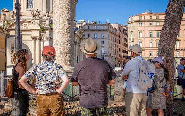Tourists observing Trajan's Column during a Rome walking tour.