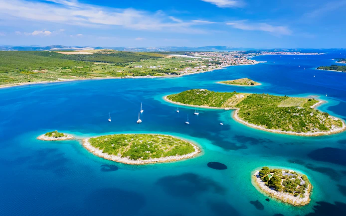 Aerial view of Kornati islands with sailboats at sunrise, Kornati National Park, Croatia.